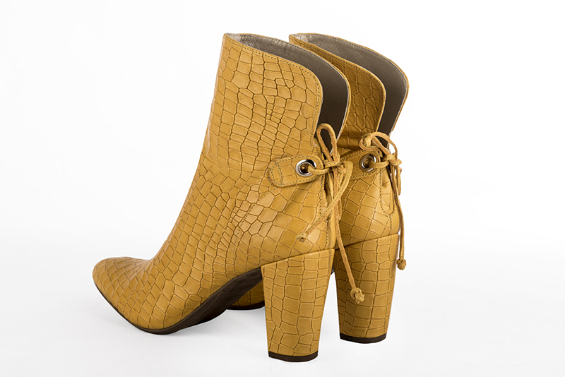 Mustard yellow women's ankle boots with laces at the back. Round toe. High block heels. Rear view - Florence KOOIJMAN